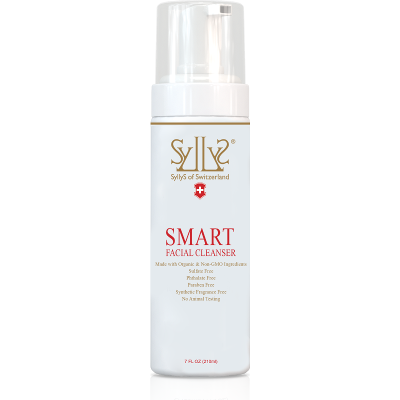SMART Facial Cleanser is in a white cylinder pump with a clear lid. On a white label SyllyS of Switzerland logo is printed in gold with the Swiss flag emblem below it. Below it the title SMART is printed in capital and with smaller text “facial cleanser” in red below it. Underneath the title, printed in gold with smaller text it states: made with organic & non GMO ingredients, sulfate free, phthalate free, paraben free, synthetic fragrance free, no animal testing. Natural Beauty Made Simple